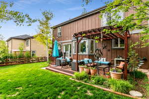 Back of house featuring a pergola, outdoor lounge area, and a lawn