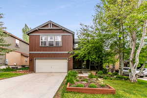 View of front of house with a garage and yard.