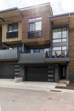 View of front facade featuring a garage and a balcony