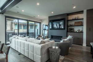 Living room with a fireplace and dark wood-type flooring