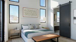 Bedroom with a barn door and wood-type flooring