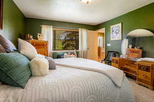 Bedroom with carpet floors and a textured ceiling