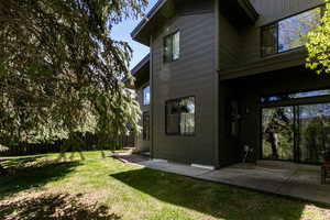 Back of property featuring a patio and a lawn