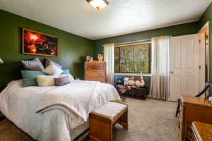 Carpeted bedroom with a textured ceiling