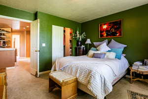 Bedroom with a textured ceiling and carpet