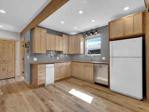 Kitchen featuring white appliances, light brown cabinets, and light hardwood / wood-style flooring