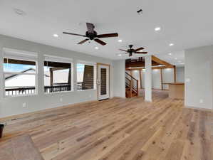 Unfurnished living room featuring ceiling fan and light hardwood / wood-style floors