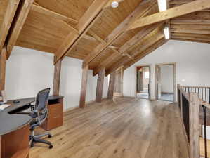 Unfurnished office with vaulted ceiling with beams, light hardwood / wood-style floors, and wooden ceiling