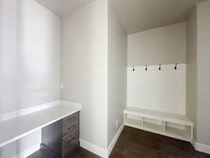 Mudroom with dark wood-style floors, baseboards, and built in study area