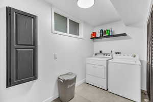 Laundry area featuring separate washer and dryer, hookup for a washing machine, light tile floors, and electric dryer hookup