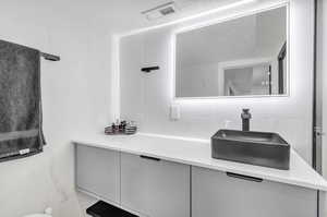 Bathroom with vanity and tile walls