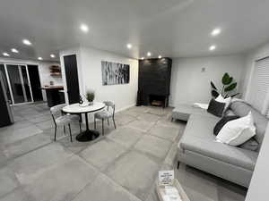 Living room featuring light tile flooring and wood burning fireplace