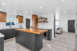 Kitchen with a healthy amount of sunlight, tasteful backsplash, a kitchen island, and wine cooler