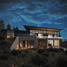 Back house at dusk featuring a balcony