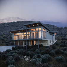 Back house at dusk featuring a balcony