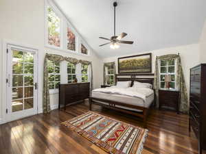 Master bedroom featuring high vaulted ceiling, dark wood-type flooring, ceiling fan, and access to your BEAUTIFUL back yard.