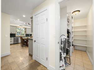 Kitchen area walk-in pantry with light tile floors