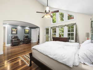 Master bedroom featuring a sitting area, high vaulted ceiling, dark wood-type flooring, ceiling fan, and access to your BEAUTIFUL back yard.