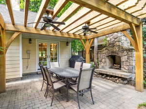 View of backyard terrace / patio with an outdoor stone fireplace, area for grilling, ceiling fans, and a pergola