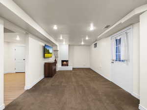 Basement living room featuring outside entrance and carpet flooring