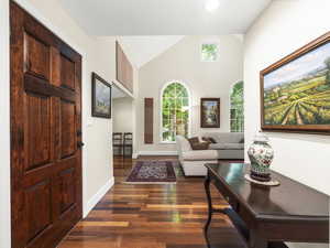 Living room with high vaulted ceiling and dark hardwood / wood-style floors