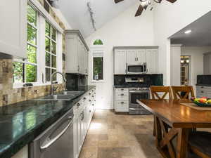 Kitchen featuring stainless steel appliances, ceiling fan, tasteful backsplash, track lighting, and sink