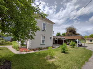 Exterior space featuring a carport and a lawn