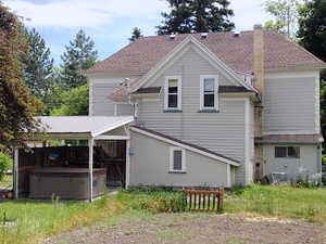 Rear view of house featuring a hot tub