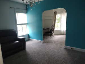 Office area with a healthy amount of sunlight, carpet floors, and an inviting chandelier