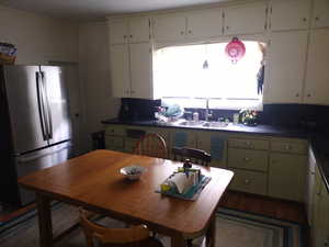 Kitchen with sink, dark hardwood / wood-style floors, stainless steel fridge, and a wealth of natural light