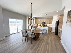 Dining area featuring sink, wood-type flooring, a textured ceiling, and a chandelier