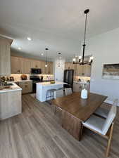 Dining area with hardwood / wood-style floors, sink, an inviting chandelier, and a textured ceiling