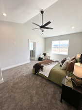 Carpeted bedroom with ceiling fan, a textured ceiling, ensuite bath, and lofted ceiling