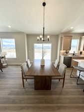 Dining space featuring light wood-type flooring, sink, an inviting chandelier, and a textured ceiling
