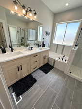 Bathroom featuring tile patterned flooring, double vanity, a textured ceiling, and separate shower and tub
