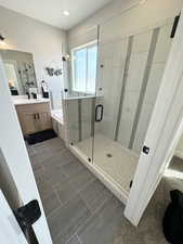 Bathroom featuring walk in shower, tile patterned flooring, and vanity