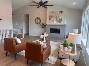 Living room with ceiling fan, hardwood / wood-style floors, and lofted ceiling