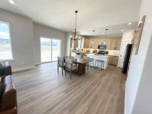 Dining area featuring a textured ceiling, light hardwood / wood-style floors, and an inviting chandelier