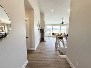 Hallway with a textured ceiling and hardwood / wood-style floors