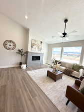 Living room with hardwood / wood-style flooring, a textured ceiling, and ceiling fan