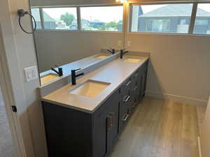 Bathroom featuring large vanity, wood-type flooring, and double sink