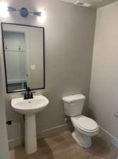 Bathroom with hardwood / wood-style floors and toilet