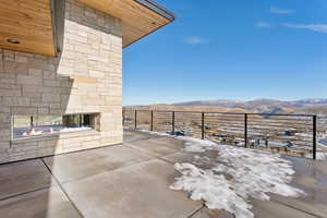 Snow covered patio with a mountain view