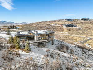 Snow covered rear of property with a mountain view