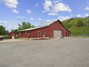 View of front facade with an outdoor structure, a mountain view, and a garage