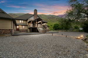 Back house at dusk featuring a patio area and a mountain view