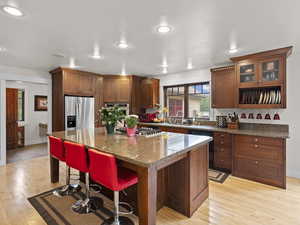 Kitchen featuring stainless steel appliances, a center island, granite counters, and hardwood floors