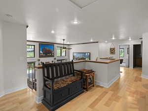 Landing with ceiling fan, hardwood flooring, seating area, and ornamental molding