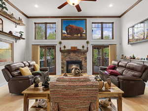 Living room with a healthy amount of sunlight, ornamental molding, and ceiling fan