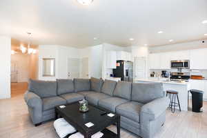 Living room featuring a notable chandelier and light wood-type flooring